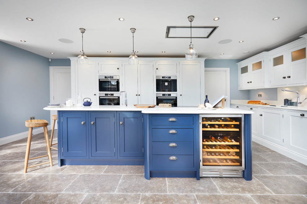 Esempio di una grande cucina classica con lavello da incasso, ante in stile shaker, ante blu, top in quarzite, paraspruzzi bianco, elettrodomestici in acciaio inossidabile, pavimento in pietra calcarea, pavimento marrone e top bianco
