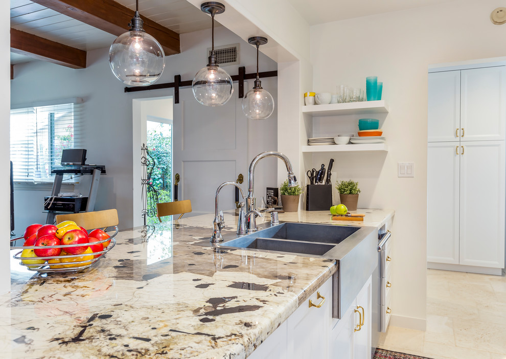 Eat-in kitchen - mid-sized transitional l-shaped travertine floor eat-in kitchen idea in Los Angeles with a farmhouse sink, white cabinets, granite countertops, stainless steel appliances, no island, white backsplash, ceramic backsplash and recessed-panel cabinets