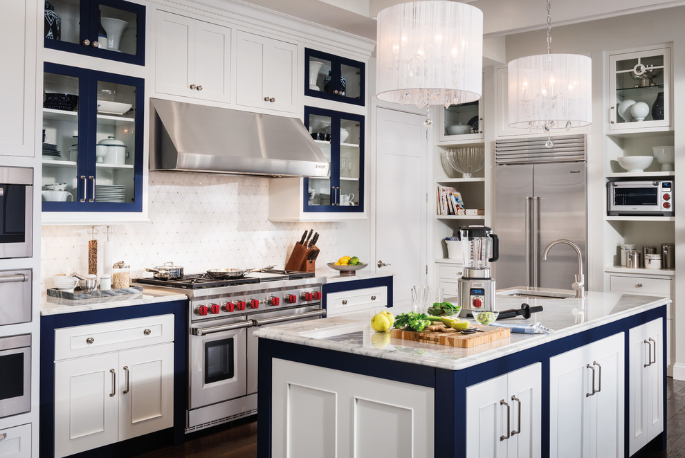 Klassische Küche in U-Form mit Küchengeräten aus Edelstahl, Kücheninsel, Schrankfronten mit vertiefter Füllung, weißen Schränken und Küchenrückwand in Weiß in Orange County