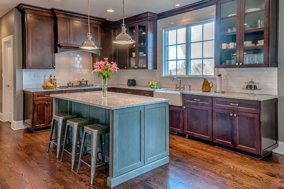 Eat-in kitchen - transitional l-shaped medium tone wood floor eat-in kitchen idea in Chicago with a farmhouse sink, shaker cabinets, gray cabinets, granite countertops, yellow backsplash, ceramic backsplash, stainless steel appliances and an island