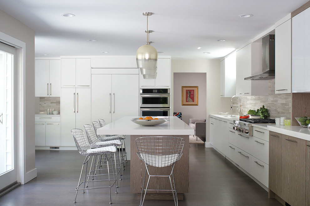 Modern inredning av ett stort, avskilt kök, med släta luckor, en köksö, en undermonterad diskho, vita skåp, beige stänkskydd och integrerade vitvaror