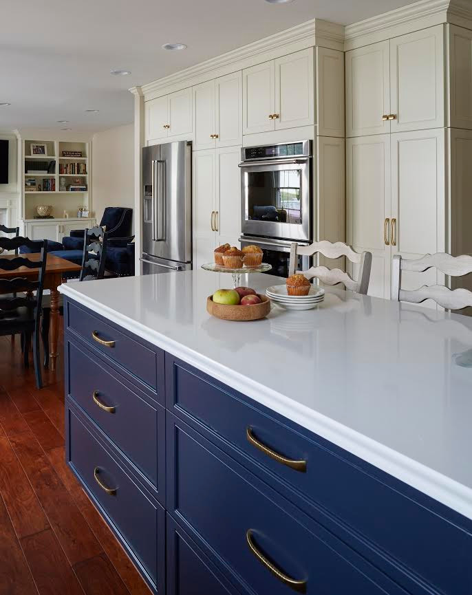 Medium sized classic l-shaped kitchen/diner in Baltimore with a submerged sink, shaker cabinets, white cabinets, engineered stone countertops, blue splashback, ceramic splashback, stainless steel appliances, dark hardwood flooring, an island, brown floors and white worktops.