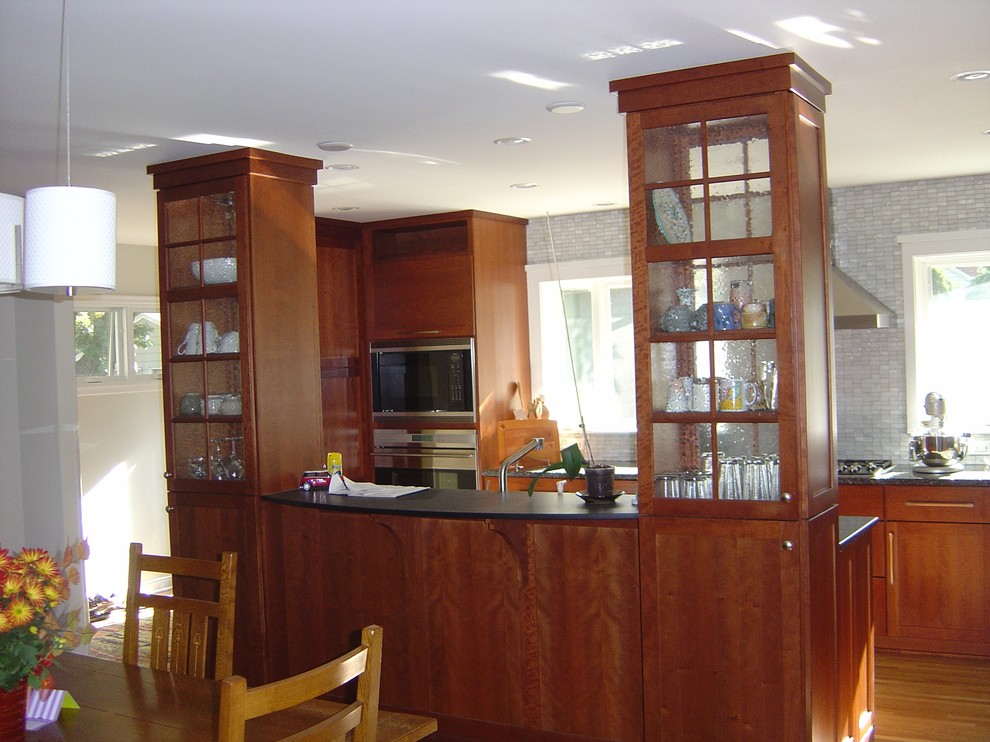 Medium sized classic galley kitchen/diner in Minneapolis with a submerged sink, shaker cabinets, medium wood cabinets, granite worktops, white splashback, glass tiled splashback, stainless steel appliances and light hardwood flooring.
