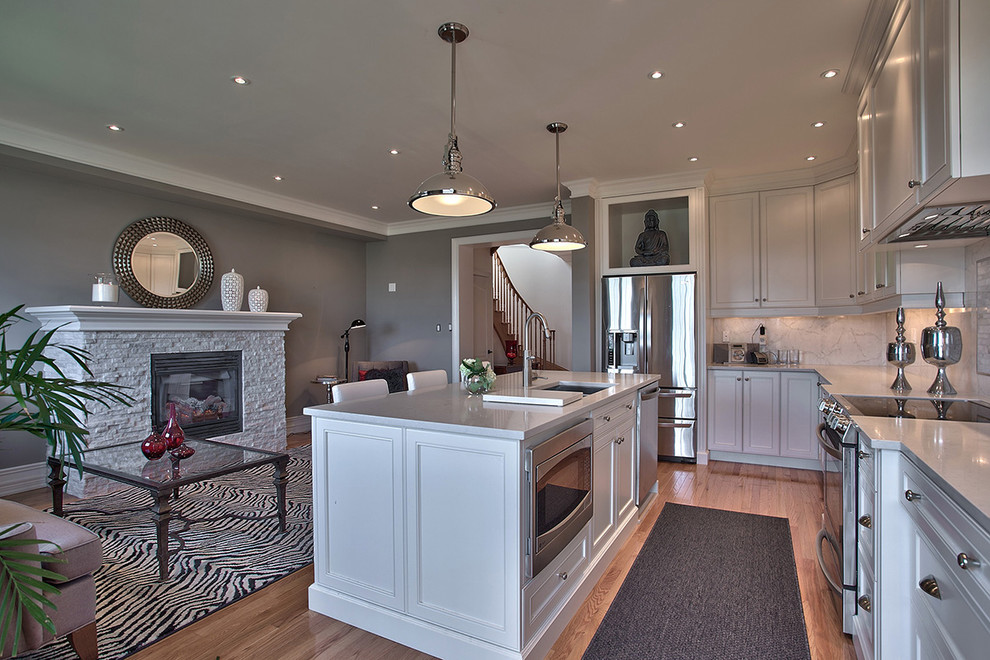 Ejemplo de cocina gris y blanca actual con electrodomésticos de acero inoxidable y chimenea
