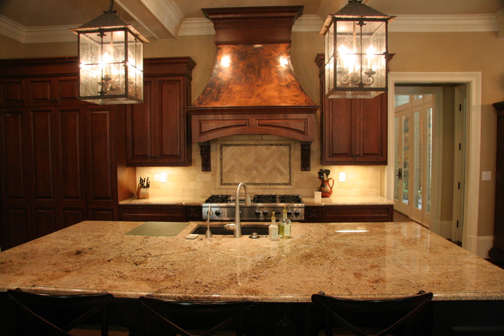 Example of a large classic l-shaped dark wood floor kitchen design in Atlanta with an undermount sink, raised-panel cabinets, dark wood cabinets, granite countertops, beige backsplash, stone tile backsplash, stainless steel appliances and an island