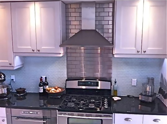 Exempel på ett modernt kök och matrum, med vita skåp, stänkskydd med metallisk yta, stänkskydd i metallkakel och rostfria vitvaror