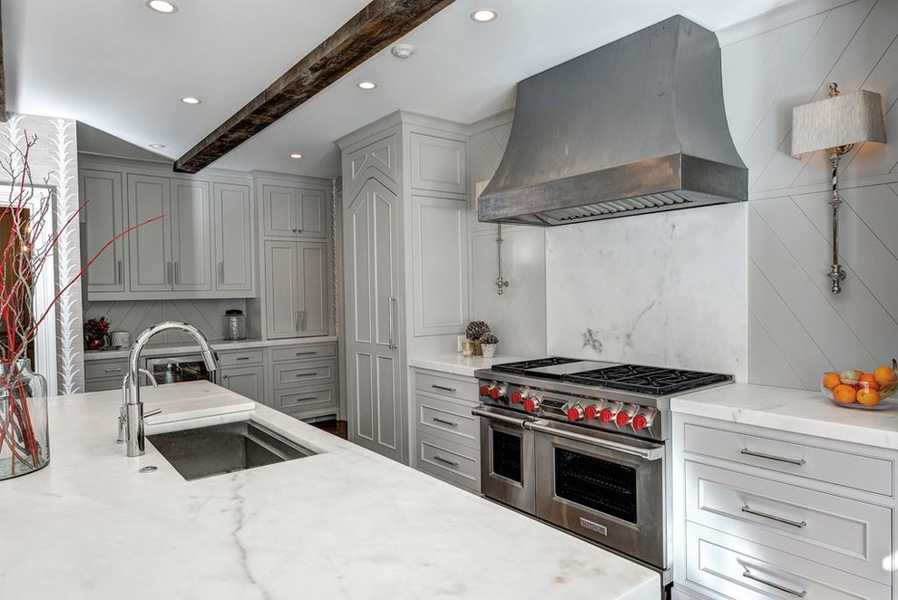 Foto på ett mellanstort funkis kök, med en undermonterad diskho, luckor med infälld panel, vita skåp, bänkskiva i zink, svart stänkskydd, stänkskydd i cementkakel, rostfria vitvaror, ljust trägolv och en köksö