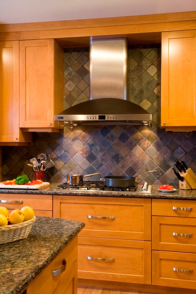 Amerikansk inredning av ett stort kök och matrum, med en undermonterad diskho, luckor med infälld panel, skåp i mellenmörkt trä, granitbänkskiva, flerfärgad stänkskydd, rostfria vitvaror, mellanmörkt trägolv och en köksö