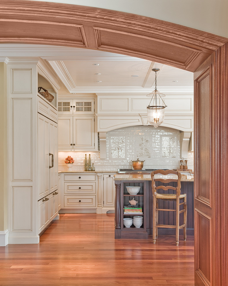 Diseño de cocina clásica con puertas de armario blancas, salpicadero blanco, armarios con paneles con relieve, electrodomésticos con paneles y barras de cocina