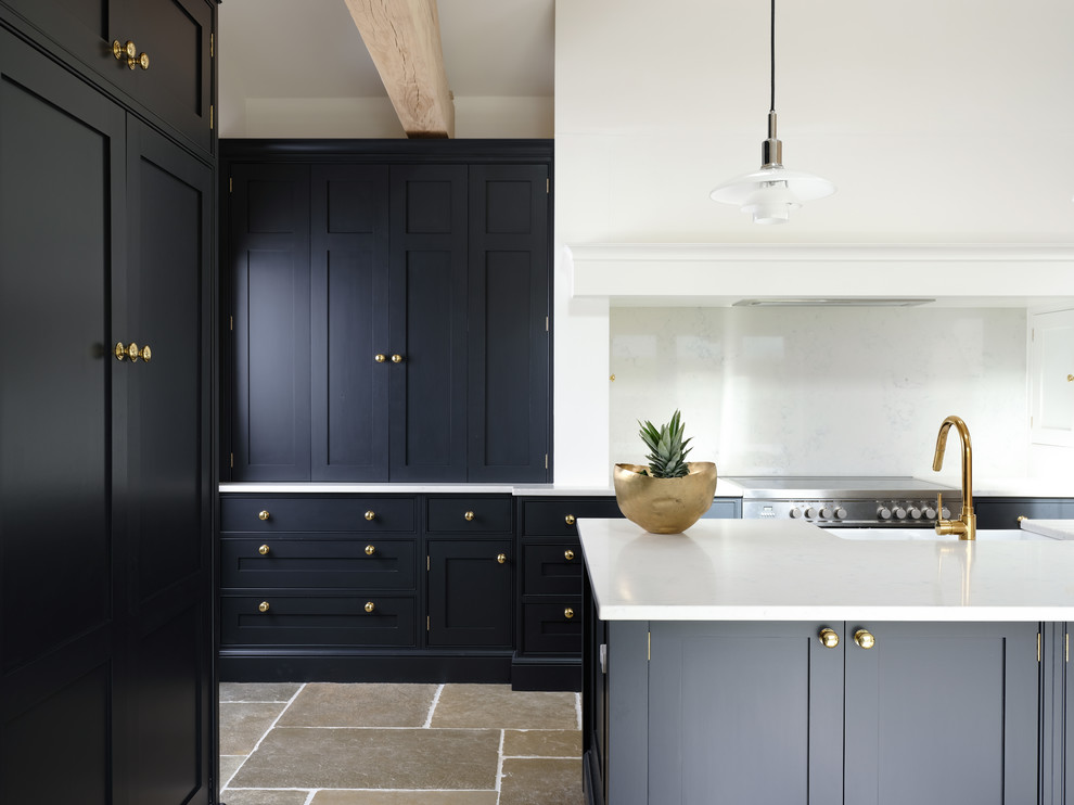 Traditional kitchen in Cheshire with a belfast sink, black cabinets, quartz worktops, an island and white worktops.