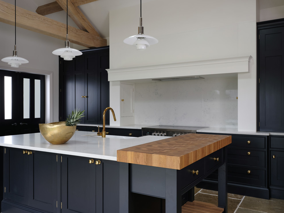 Klassische Küche mit Landhausspüle, schwarzen Schränken, Quarzit-Arbeitsplatte, Kücheninsel und weißer Arbeitsplatte in Cheshire