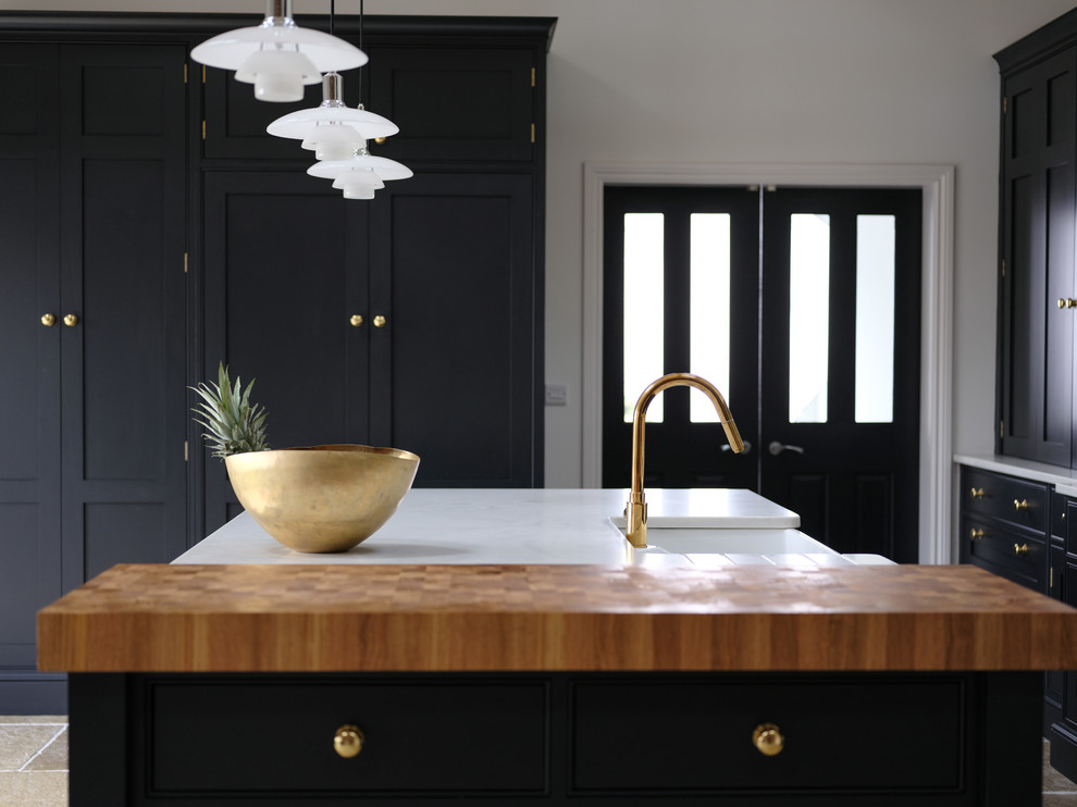 Imagen de cocina clásica renovada con fregadero sobremueble, puertas de armario negras, encimera de cuarcita, una isla y encimeras blancas