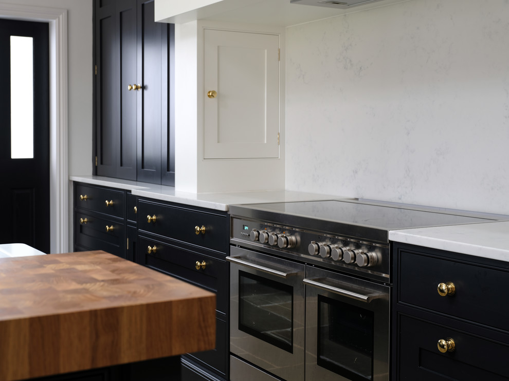 Foto de cocina clásica renovada con fregadero sobremueble, puertas de armario negras, encimera de cuarcita, una isla y encimeras blancas