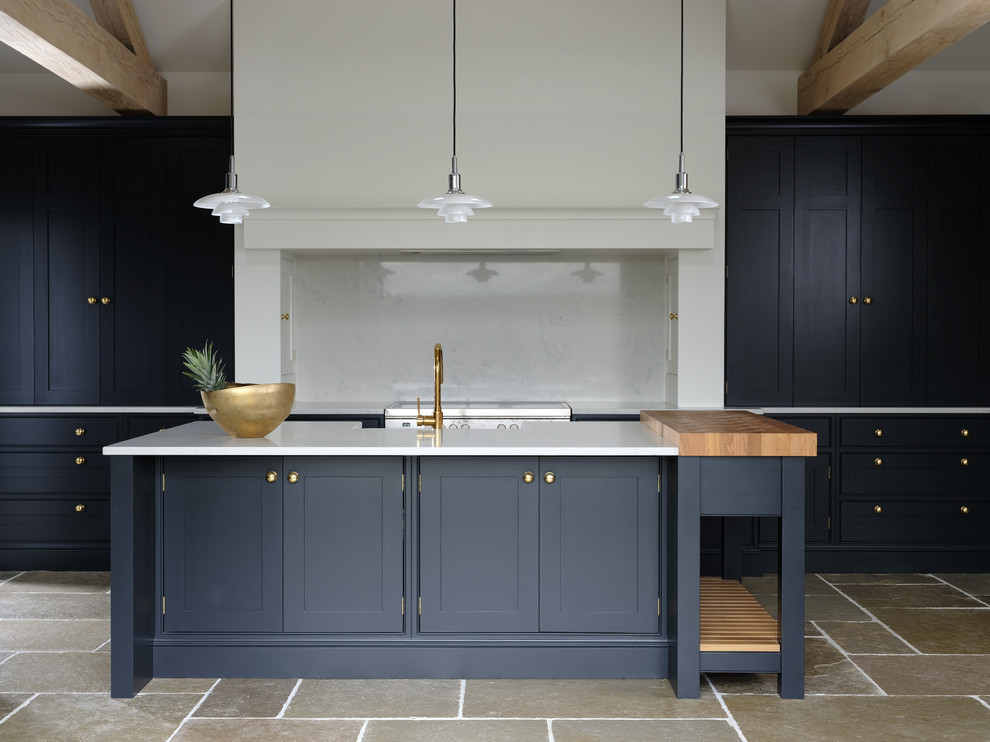Design ideas for a classic kitchen in Cheshire with a belfast sink, black cabinets, quartz worktops, an island, white worktops, shaker cabinets, white splashback, stainless steel appliances and grey floors.