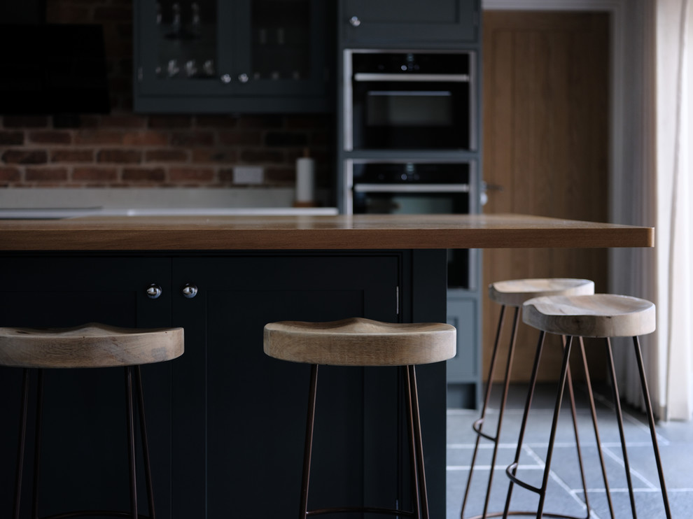 Photo of a classic kitchen in Cheshire with quartz worktops, slate flooring, an island and grey floors.