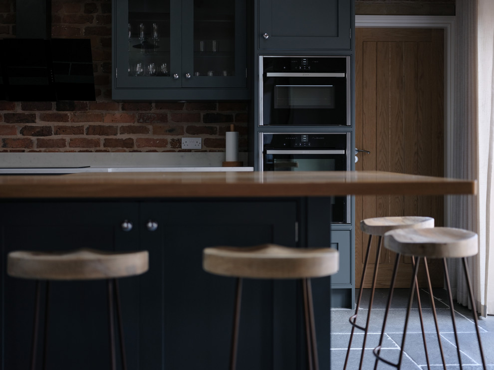 Classic kitchen in Cheshire with quartz worktops, slate flooring, an island and grey floors.