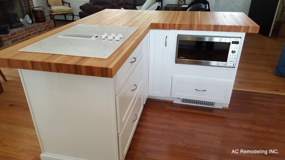 Esempio di una cucina minimalista con top in legno, elettrodomestici in acciaio inossidabile e parquet chiaro