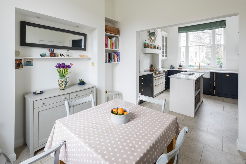 Inspiration for a small traditional l-shaped kitchen/diner in London with a belfast sink, shaker cabinets, black cabinets, quartz worktops, limestone flooring, an island and beige floors.