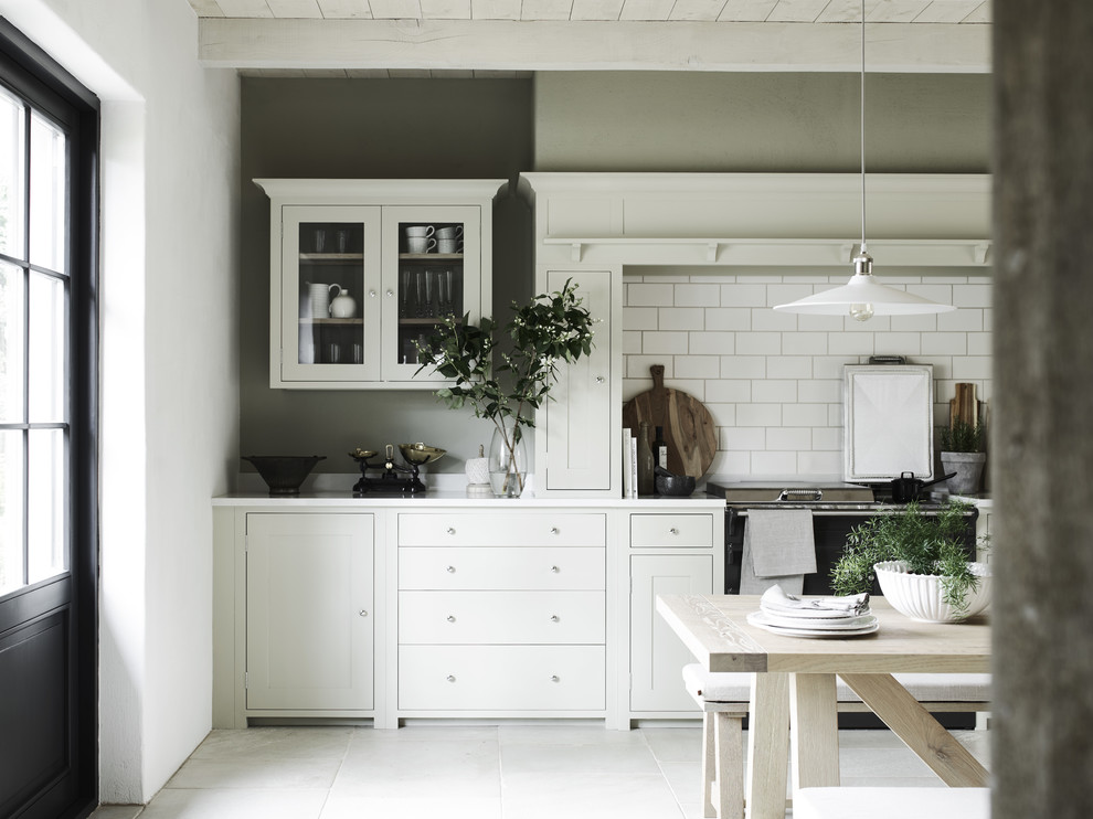 Diseño de cocina lineal campestre con armarios estilo shaker, puertas de armario grises, salpicadero blanco, salpicadero de azulejos tipo metro y suelo gris