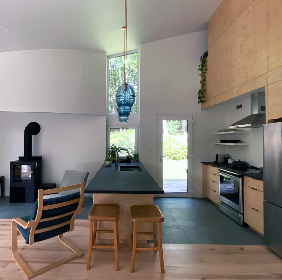 Inspiration pour une petite cuisine ouverte parallèle minimaliste en bois clair avec un plan de travail en surface solide, un sol en ardoise, un sol noir et plan de travail noir.