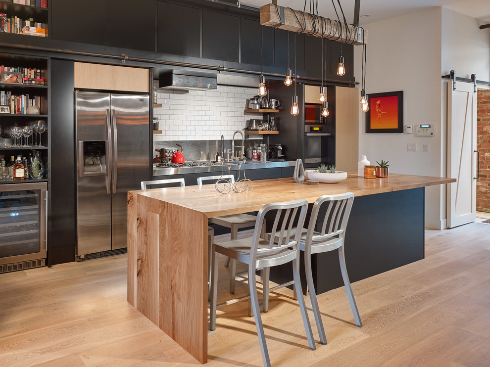 Foto på ett mellanstort eklektiskt linjärt kök med öppen planlösning, med svarta skåp, träbänkskiva, vitt stänkskydd, stänkskydd i keramik, rostfria vitvaror och en köksö