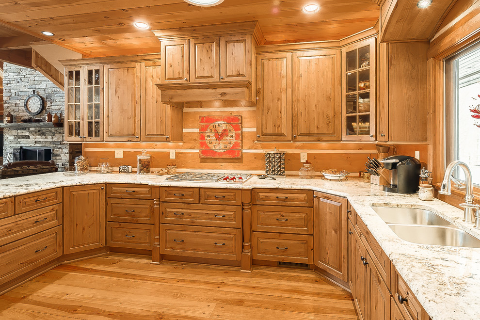 Inspiration for a large rustic u-shaped medium tone wood floor open concept kitchen remodel in Charlotte with raised-panel cabinets, granite countertops, a peninsula, a double-bowl sink, light wood cabinets, brown backsplash and paneled appliances