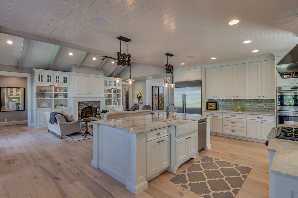 Große, Offene Moderne Küche mit Landhausspüle, weißen Schränken, Quarzit-Arbeitsplatte, Küchengeräten aus Edelstahl, hellem Holzboden und Kücheninsel in Boise
