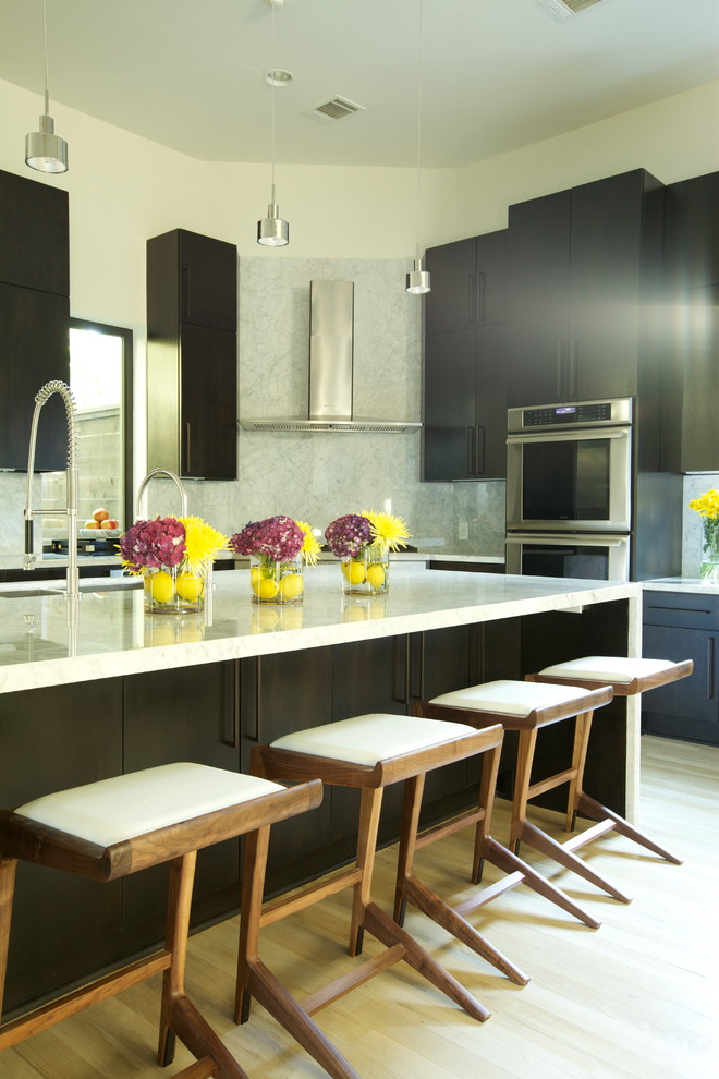 Exempel på ett modernt kök, med en dubbel diskho, släta luckor, skåp i mörkt trä, marmorbänkskiva, vitt stänkskydd och rostfria vitvaror