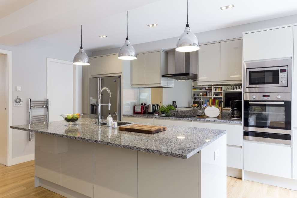 Esempio di una cucina design di medie dimensioni con lavello sottopiano, ante lisce, ante beige, top in granito, parquet chiaro e pavimento beige