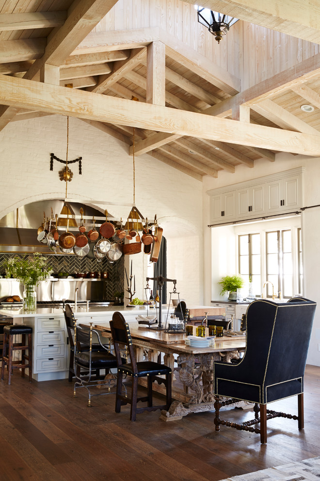 This is an example of a large mediterranean kitchen/diner in Los Angeles with dark hardwood flooring and an island.