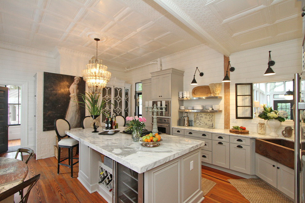 Immagine di una grande cucina classica con lavello stile country, ante con bugna sagomata, ante grigie, top in marmo, paraspruzzi bianco e pavimento in legno massello medio