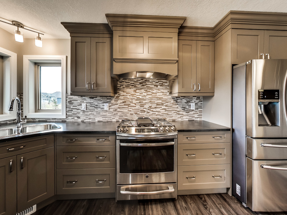 Design ideas for a classic u-shaped kitchen/diner in Calgary with shaker cabinets, grey cabinets, laminate countertops, grey splashback, mosaic tiled splashback, stainless steel appliances, vinyl flooring and a breakfast bar.