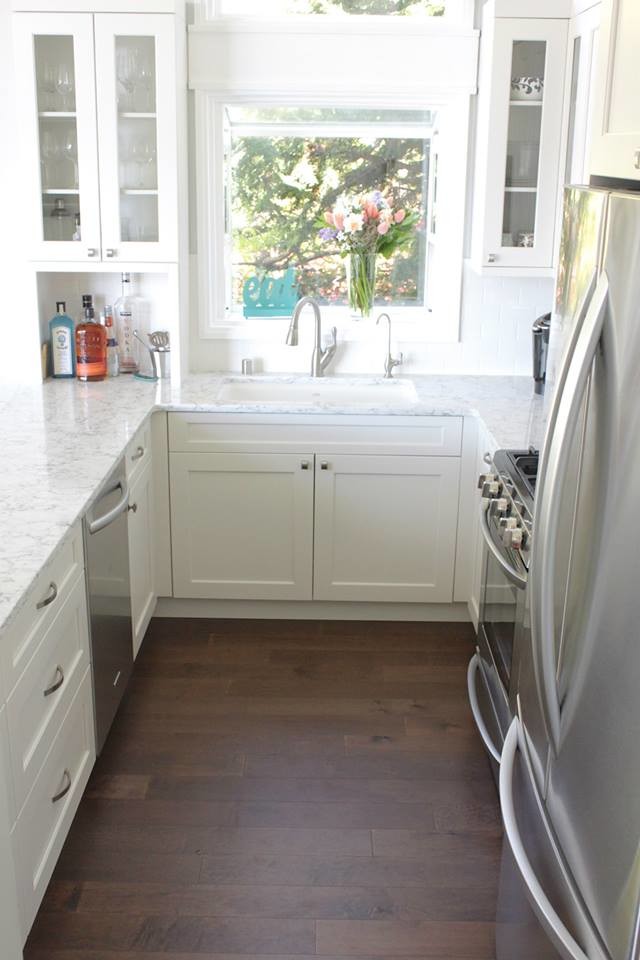 Photo of a small classic u-shaped kitchen/diner in Seattle with a submerged sink, shaker cabinets, white cabinets, quartz worktops, white splashback, metro tiled splashback and stainless steel appliances.