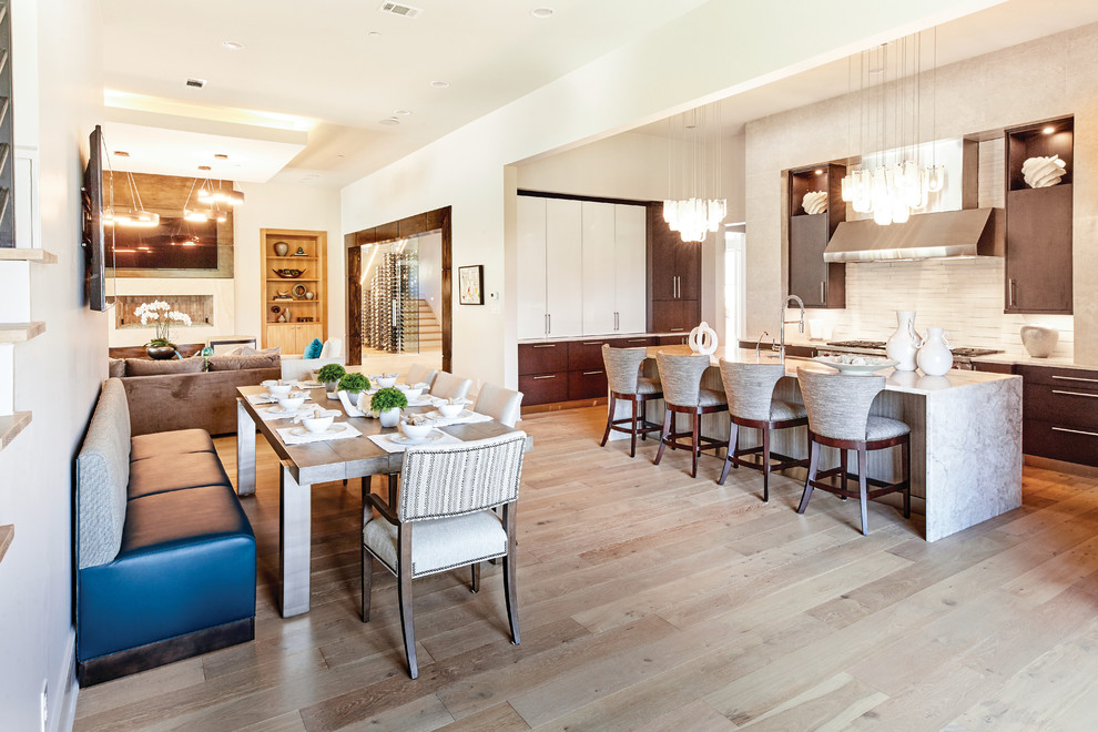 Example of a mid-sized trendy single-wall light wood floor and brown floor eat-in kitchen design in Dallas with flat-panel cabinets, dark wood cabinets, granite countertops, beige backsplash, an island and beige countertops