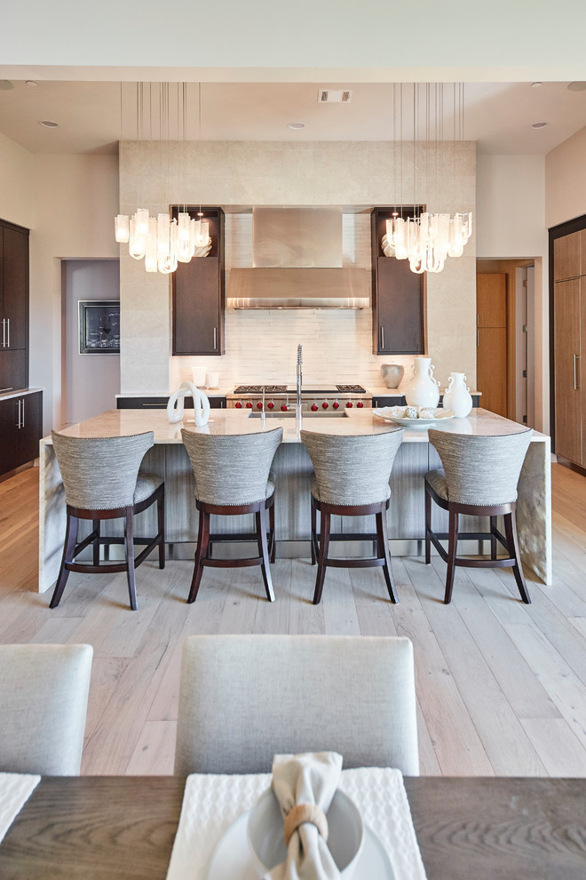 Mid-sized trendy single-wall light wood floor and brown floor eat-in kitchen photo in Dallas with a farmhouse sink, flat-panel cabinets, dark wood cabinets, granite countertops, beige backsplash, stainless steel appliances, an island and beige countertops