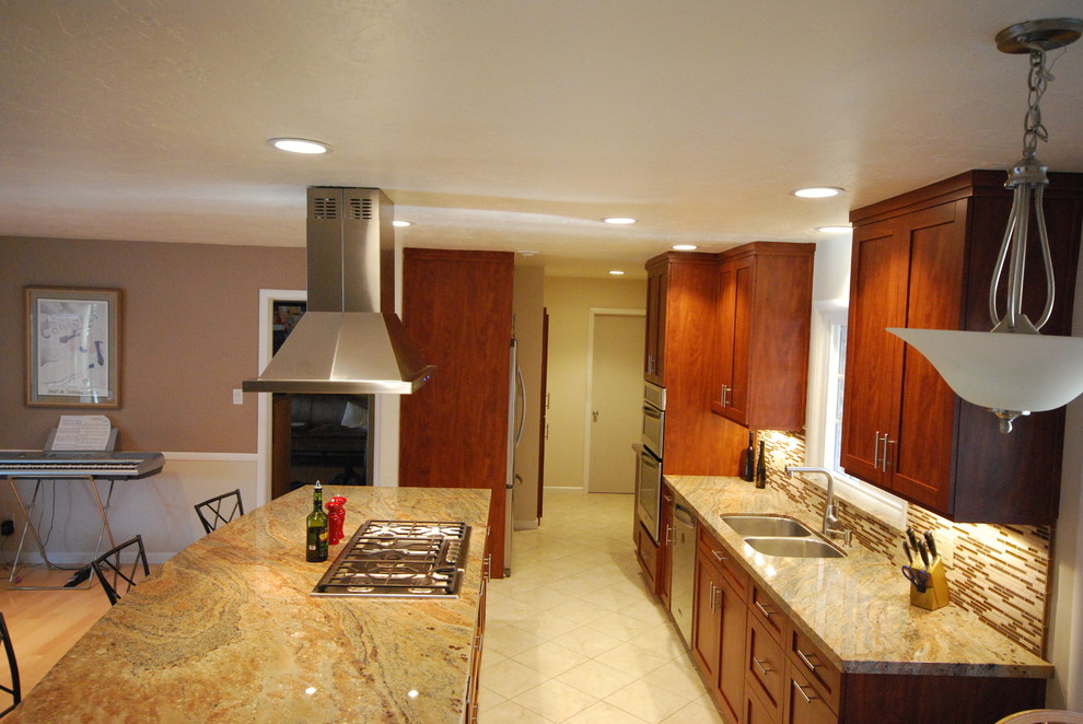 Bild på ett mellanstort funkis linjärt kök och matrum, med en dubbel diskho, skåp i shakerstil, granitbänkskiva, flerfärgad stänkskydd, stänkskydd i glaskakel, rostfria vitvaror, ljust trägolv, en köksö och skåp i mörkt trä