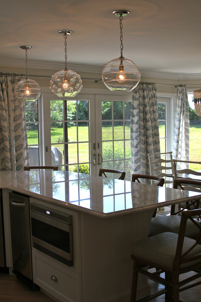 Idéer för maritima kök, med en undermonterad diskho, luckor med upphöjd panel, vita skåp, marmorbänkskiva, vitt stänkskydd och rostfria vitvaror