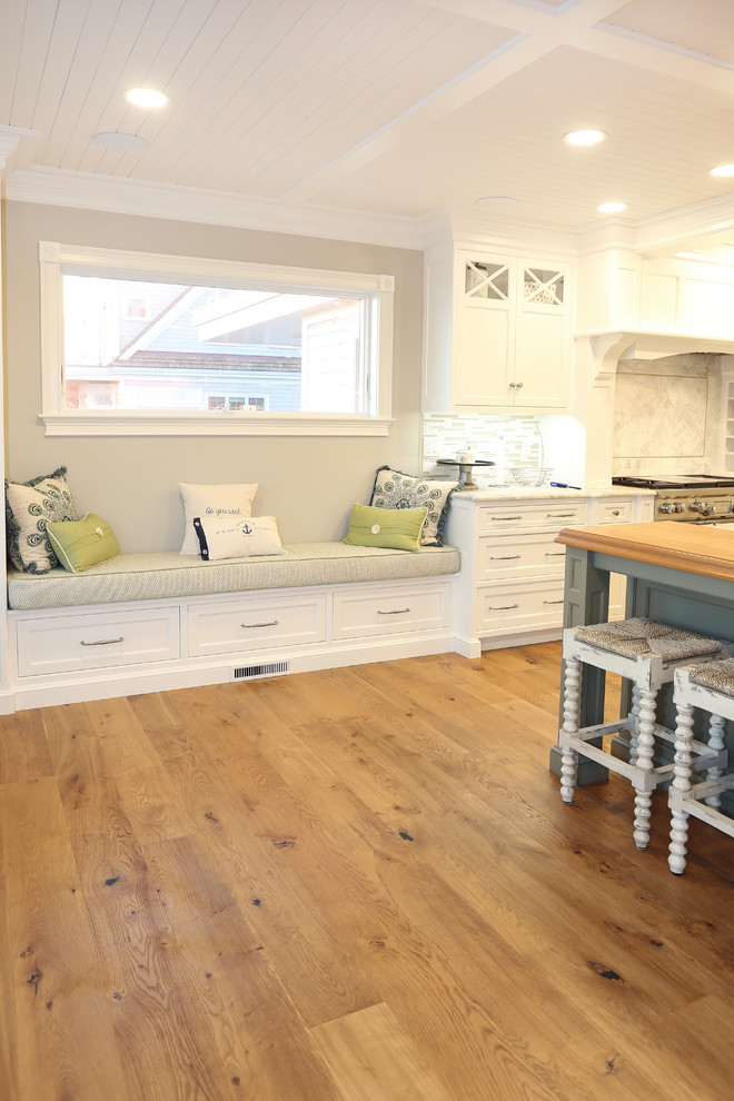 Imagen de cocina marinera grande abierta con electrodomésticos de acero inoxidable, suelo de madera en tonos medios, una isla y suelo marrón