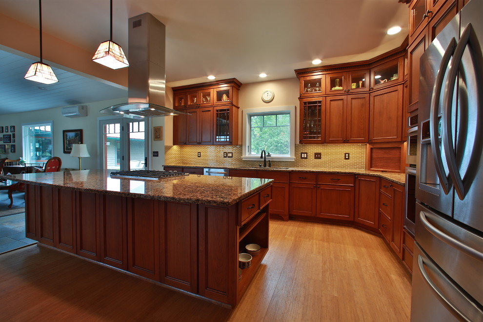 Inspiration for a large craftsman l-shaped bamboo floor eat-in kitchen remodel in Burlington with flat-panel cabinets, medium tone wood cabinets, quartz countertops, green backsplash, glass tile backsplash, stainless steel appliances and an island