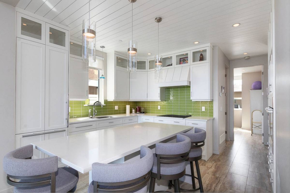 Bild på ett litet maritimt vit vitt kök, med en undermonterad diskho, skåp i shakerstil, vita skåp, bänkskiva i kvartsit, grönt stänkskydd, stänkskydd i glaskakel, integrerade vitvaror, vinylgolv, en köksö och grått golv
