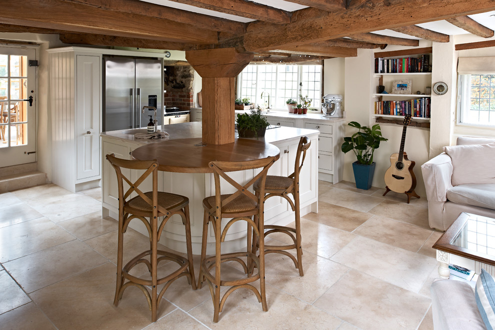 Mittelgroße Klassische Wohnküche mit Mineralwerkstoff-Arbeitsplatte, Küchengeräten aus Edelstahl, Kalkstein, Kücheninsel und beigem Boden in Oxfordshire