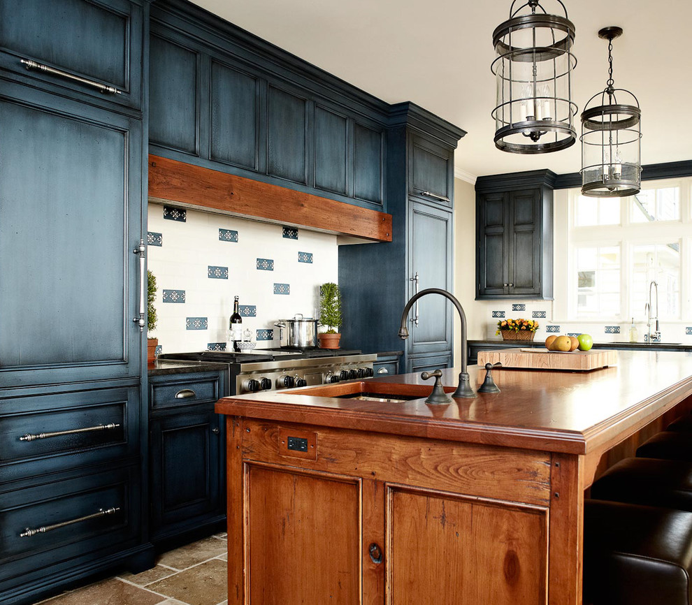Elegant kitchen photo in New York with wood countertops, recessed-panel cabinets, blue cabinets and paneled appliances