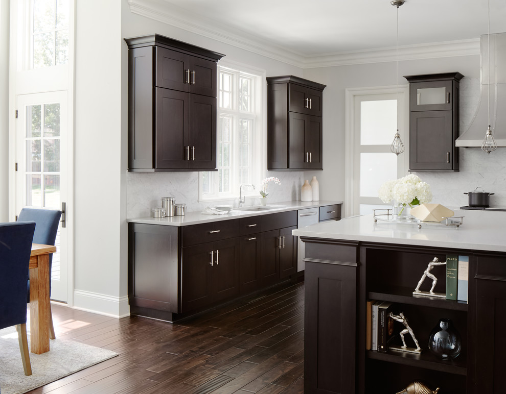 Large trendy u-shaped dark wood floor open concept kitchen photo in Chicago with a double-bowl sink, flat-panel cabinets, dark wood cabinets, gray backsplash, stainless steel appliances and an island