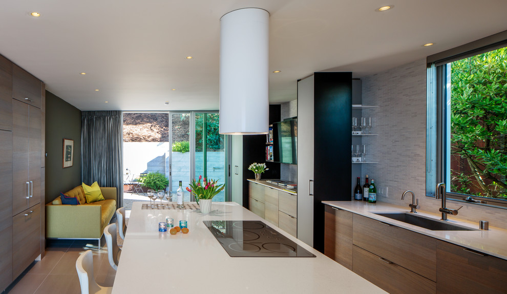 Immagine di una cucina moderna con lavello sottopiano, ante lisce, ante grigie, paraspruzzi multicolore, elettrodomestici in acciaio inossidabile, pavimento grigio e top bianco