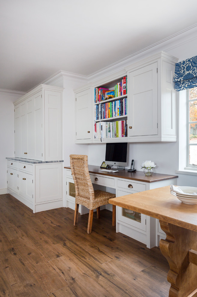 Offene Klassische Küche mit Landhausspüle, Kassettenfronten, blauen Schränken, Granit-Arbeitsplatte, Küchenrückwand in Schwarz, Glasrückwand und Kücheninsel in Kent