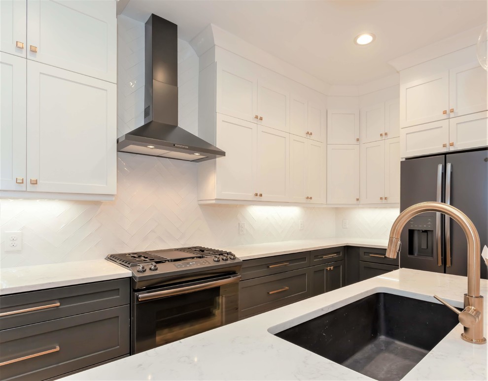 Foto på ett mellanstort funkis vit kök, med en undermonterad diskho, skåp i shakerstil, svarta skåp, bänkskiva i kvarts, vitt stänkskydd, stänkskydd i keramik, svarta vitvaror, ljust trägolv och en köksö