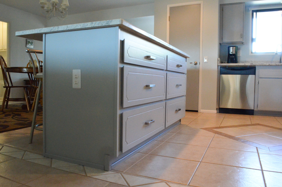 Immagine di una cucina design di medie dimensioni con lavello sottopiano, ante lisce, ante grigie, top in granito, paraspruzzi grigio, elettrodomestici in acciaio inossidabile e pavimento con piastrelle in ceramica