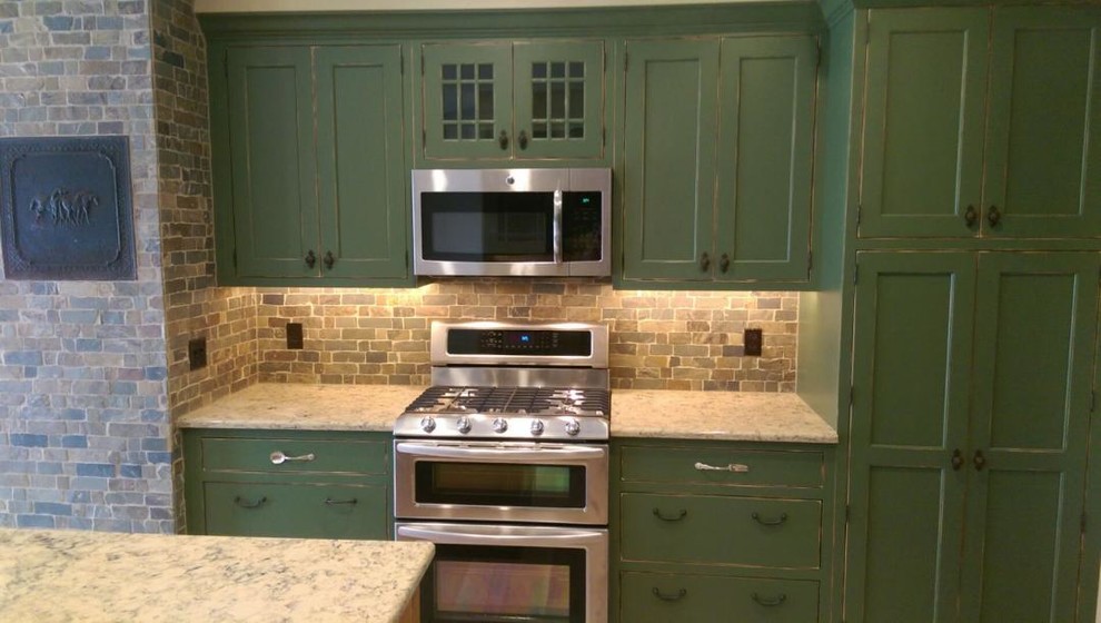 Kitchen - mid-sized cottage u-shaped light wood floor kitchen idea in Other with shaker cabinets, green cabinets, granite countertops, multicolored backsplash, stone tile backsplash, an island, a farmhouse sink and stainless steel appliances