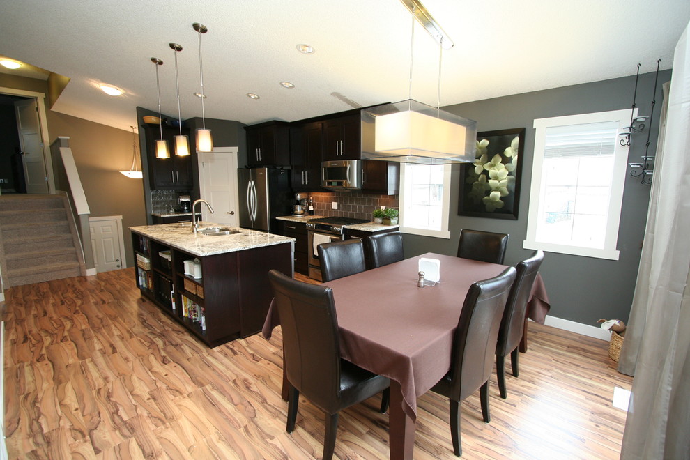 Example of a small trendy galley eat-in kitchen design in Edmonton with an undermount sink, shaker cabinets, dark wood cabinets, granite countertops, gray backsplash, glass tile backsplash and stainless steel appliances