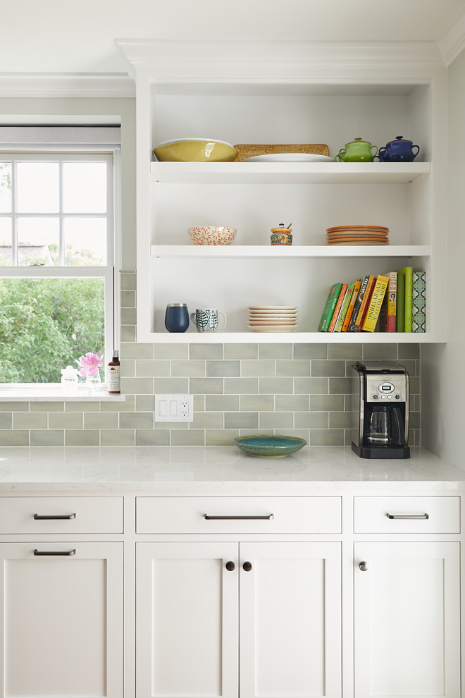 Inspiration for a traditional enclosed kitchen in Minneapolis with a double-bowl sink, shaker cabinets, white cabinets, engineered stone countertops, green splashback, porcelain splashback, stainless steel appliances, medium hardwood flooring, an island and grey worktops.
